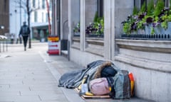A homeless person sleeping on the pavement on Aldgate High Street in London.