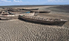 Stationary engineless boats lie idle on a dry inland lake in Africa