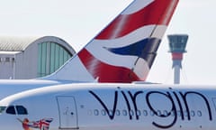 A British Airways aeroplane tailfin and a Virgin Atlantic aeroplane by the control tower at Heathrow airport