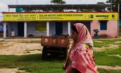 Solar Rooftop Panels and Microgrids in Rural India<br>A woman walks past a solar power microgrid power station in the village of Dharnai in Jehanabad, Bihar, India, on Thursday, July 9, 2015. While Prime Minister Narendra Modi's ambition has led billionaires such as Foxconn Technology Group's Terry Gou to pledge investment, the question remains whether the 750 million Indians living on less than $2 per day can afford or will embrace green energy.