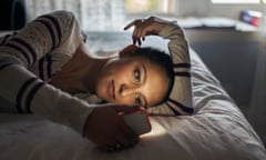 Teen (16-17) girl lying on bed using smartphone<br>GettyImages-523130512