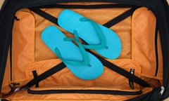 A close up shot of carry on luggage with flip flops