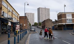 A young family walking past a small shopping area in Highgate, Birmingham