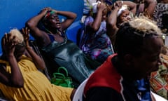 A group of black women praying with hands on their heads