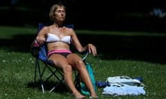 A woman in a bikini sitting on a foldaway chair in Green Park, London