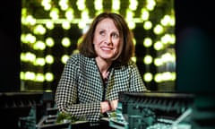 Shirine Khoury-Haq sitting in front of a decorative display of green lightbulbs by a model of a modern arena