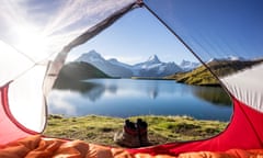 Tent pitched on shore of a lake backed by mountains