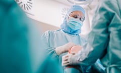 Doctors conducting knee replacement surgery on a patient