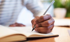 Man's hand writing in a notebook.