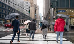 People with umbrellas walk on the street on a rainy day in Manhattan 