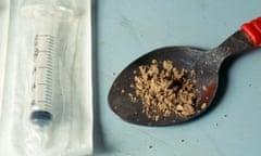 Heroin in a spoon beside syringe