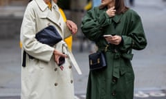 Two women in trenchcoats in a candid moment
