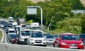 heavy traffic coastbound on the M3 near Winchester, Hampshire, 12 August 2024: a red car leads long lines of mostly silver or white cars, vans and trucks