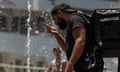 A person cools off in a water fountain by the Hudson River in New York City on 20 June. 