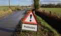 Sign warning of potholes in country road