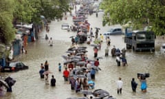 People walk on a flooded street after torrential rains paralysed Mumbai, July 2005. 