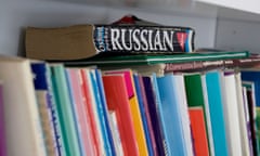 Line of school books and study materials on the shelf with a Russian dictionary on top of the stack.