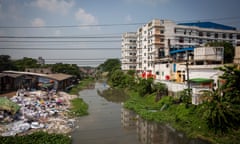 River with waste on the left and buildings to the right