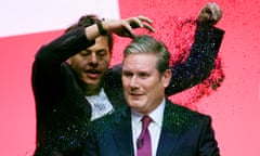 A protester throws glitter over the Labour party leader, Sir Keir Starmer.