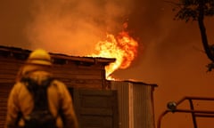 A firefighter works to save a burning structure amid the Park Fire in the community of Cohasset near Chico, California.
