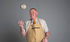 Keith Brymer Jones in a potter's apron ready to catch a lump of clay in his right hand