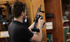 A customer inspects a gun at a gun store.