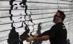 Manuel Oliver, the father of slain high school student Joaquin Oliver, works on a painting on the US border wall, part of his activism since the death of his son.
