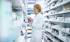 A pharmacist looks through the shelves at a chemist.