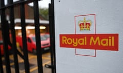 A Royal Mail logo on a black gate with bars and a red van in the background
