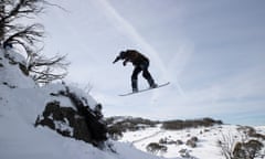 Rick from Melbourne comes off a rock outcrop at centre valley on empty ski runs before the opening of the resort at Perisher in 2022