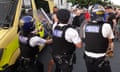 Riot police hold back large group of men