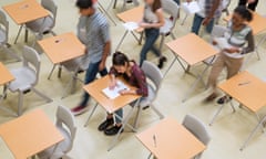 Elevated view of students writing their GCSE exam in classroom.