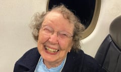 Patricia smiles as she sits in a window seat on a plane