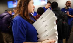 An Apple employee carries iPad Air boxes.