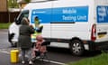 Members of the public use an NHS Test and Trace mobile coronavirus testing unit in London.