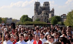 People attend a Good Friday "Stations of the Cross" procession, as part of Holy Week celebrations, along the banks of the River Seine near Notre-Dame Cathedral in Paris<br>People attend a Good Friday "Stations of the Cross" procession, as part of Holy Week celebrations, along the banks of the River Seine, near Notre-Dame Cathedral devastated by a fire at the start of the week, in Paris, France, April 19, 2019. REUTERS/Gonzalo Fuentes