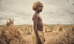 Aswan Reid in The New Boy, standing surrounded by haystacks