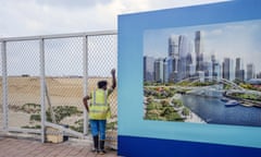 Construction and Development at the Port City Colombo Project<br>A worker looks out at the site of the Colombo Port City while standing next to a hoarding featuring an artist's impression of the Colombo International Financial City project, both developed by China Harbour Engineering Co., a unit of China Communications Construction Co., in Colombo, Sri Lanka, on Saturday, March 31, 2018. The projects are two of several in Sri Lanka that offer lessons for countries looking to snag some of the more than $500 billion projected to underpin Chinese President Xi Jinpings Belt and Road infrastructure initiative. Photographer: Atul Loke/Bloomberg via Getty Images