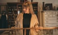 A woman inspects inventory in a display unit in a furniture store.