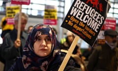 A woman holds up a placard saying: 'Refugees welcome'