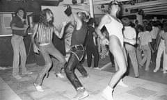 Black-and-white photo of people dancing on a dancefloor, one in a leotard