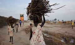 A young woman carries firewood after returning to the United Nations base outside Bentiu