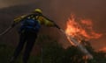 firefighter sprays the flames of a wildfire in California.