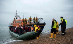 Migrants are helped ashore from a RNLI (Royal National Lifeboat Institution) lifeboat.