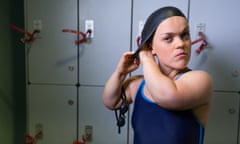 Ellie Simmonds in her swimming costume, putting on her swimming hat, in front of lockers