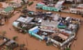 Residents stand on rooftops in a flooded area of Buzi, central Mozambique