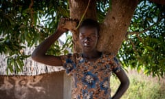 A teenage girl standing under a tree