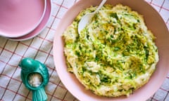 A pink bowl on a table containing leek and brussel sprout colcannon.