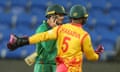 South Africa's Quinton de Kock chats with Zimbabwe's Regis Chakabva as the rain comes down in Hobart