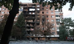 A burned out apartment building with shattered windows